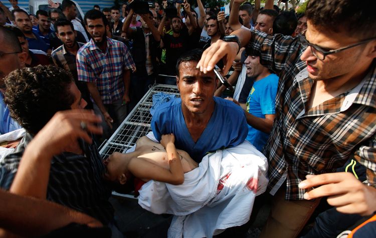 671018-medic-carries-the-body-of-a-boy-following-his-death-at-a-hospital-in-gaza-city