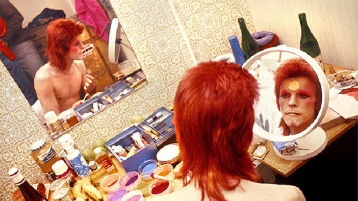 David Bowie séance de maquillage devant un miroir rond . Photo Mike Rock  Ecosse 1973.